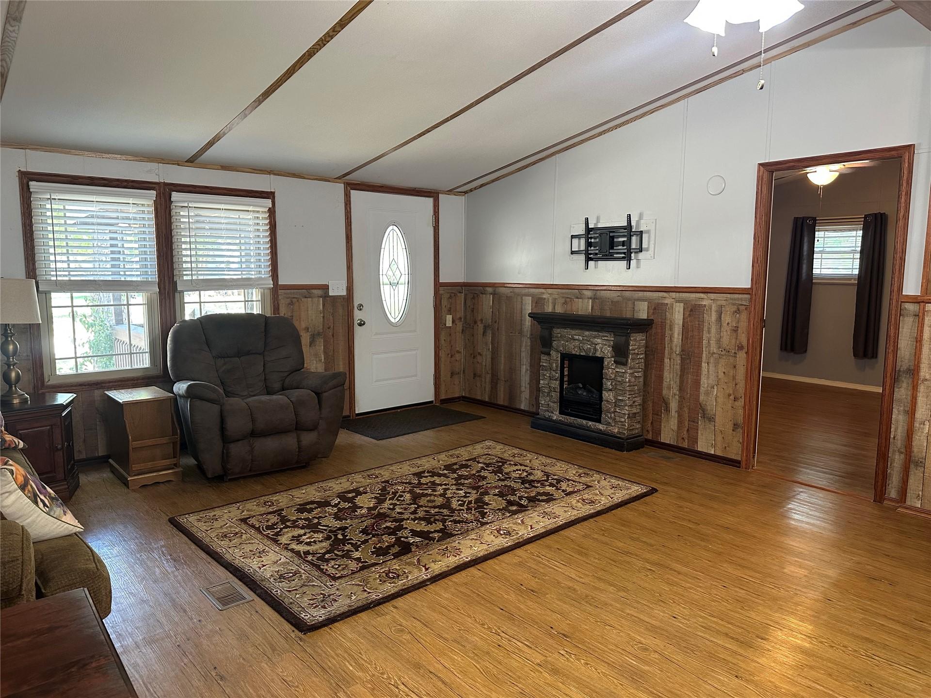 Image 2: Living area featuring wood-finish flooring, wood p