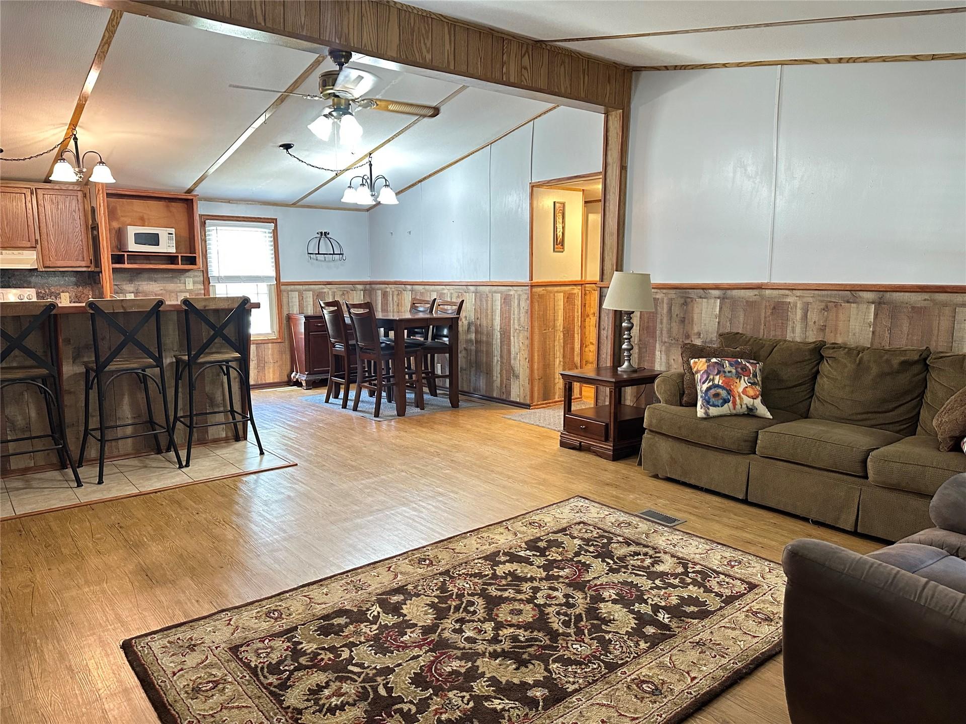 Image 3: Open-concept living area featuring wood-finish flo