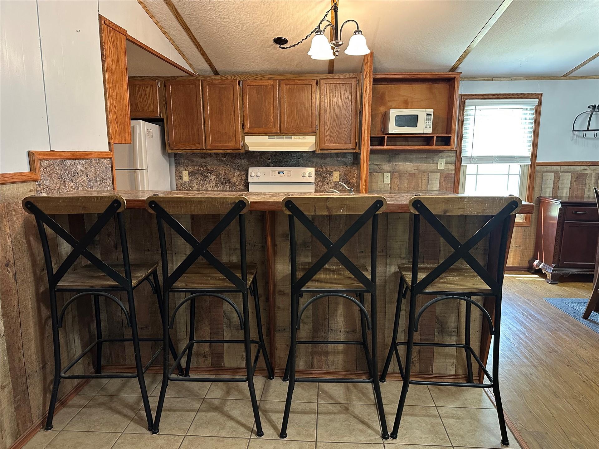 Image 4: Kitchen area featuring wood-finish cabinetry, a bu