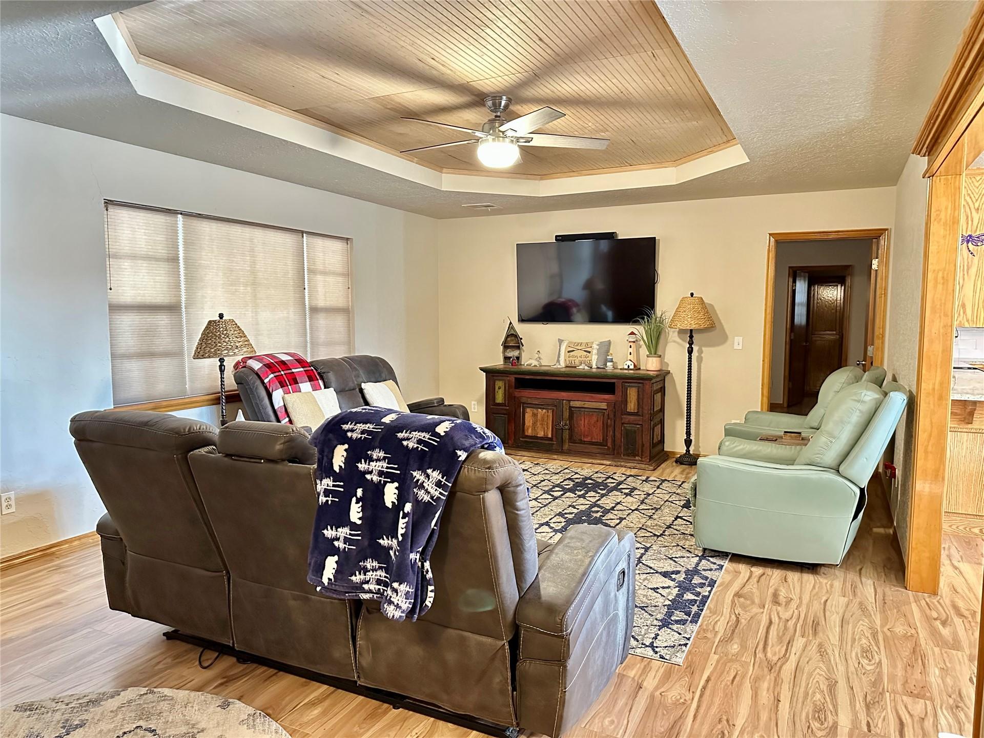 Image 3: Living area featuring a tray ceiling with wood-fin