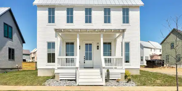 Image 2: White two-story residence featuring horizontal sid