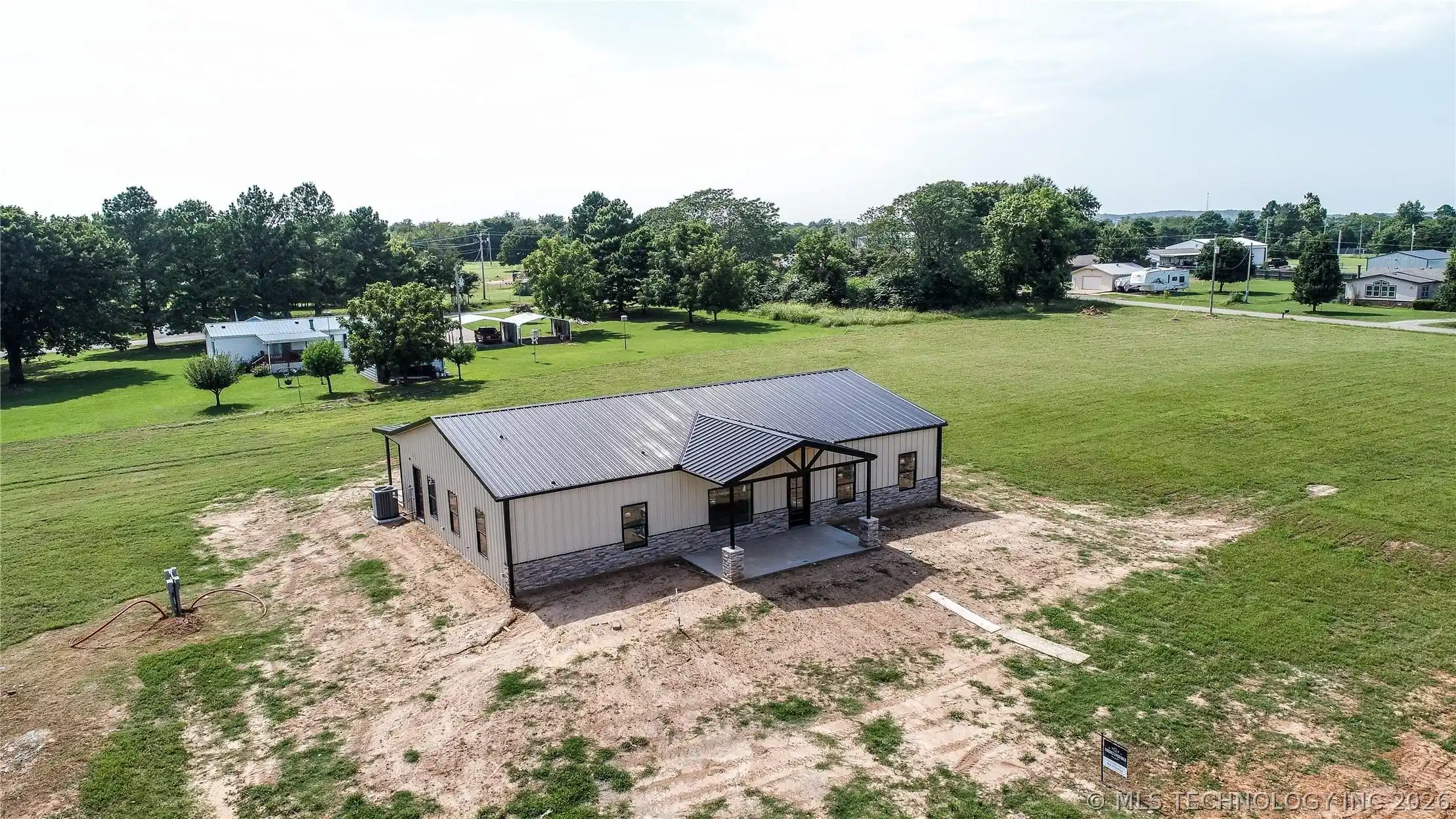 Image 1: Modern build featuring a metal roof, light-toned s