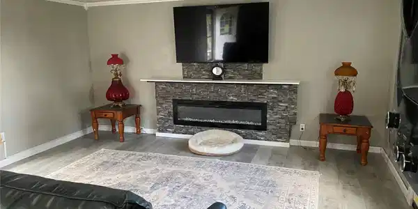 Image 2: Living area featuring a floor-to-ceiling stone-loo