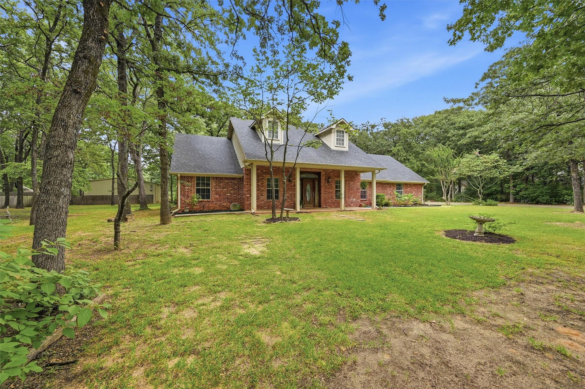 Image 1: Brick exterior residence featuring a covered front