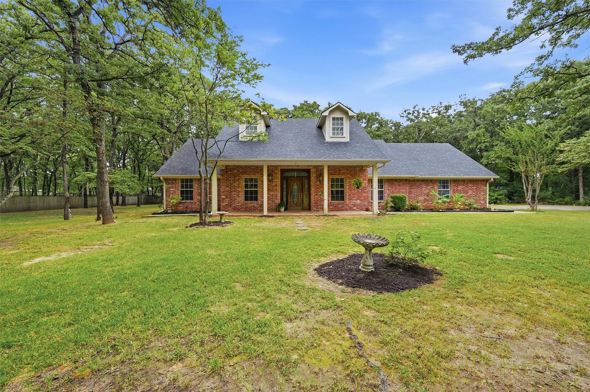 Image 4: Brick exterior with a dark shingle roof, dormer wi