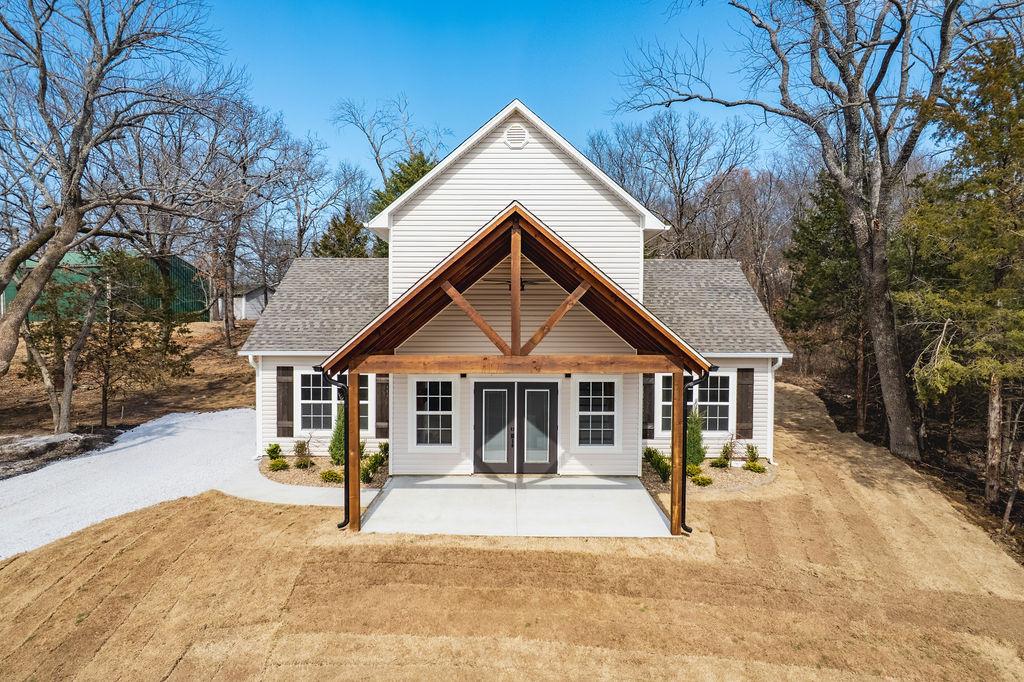 Image 1: White siding exterior with a prominent covered por