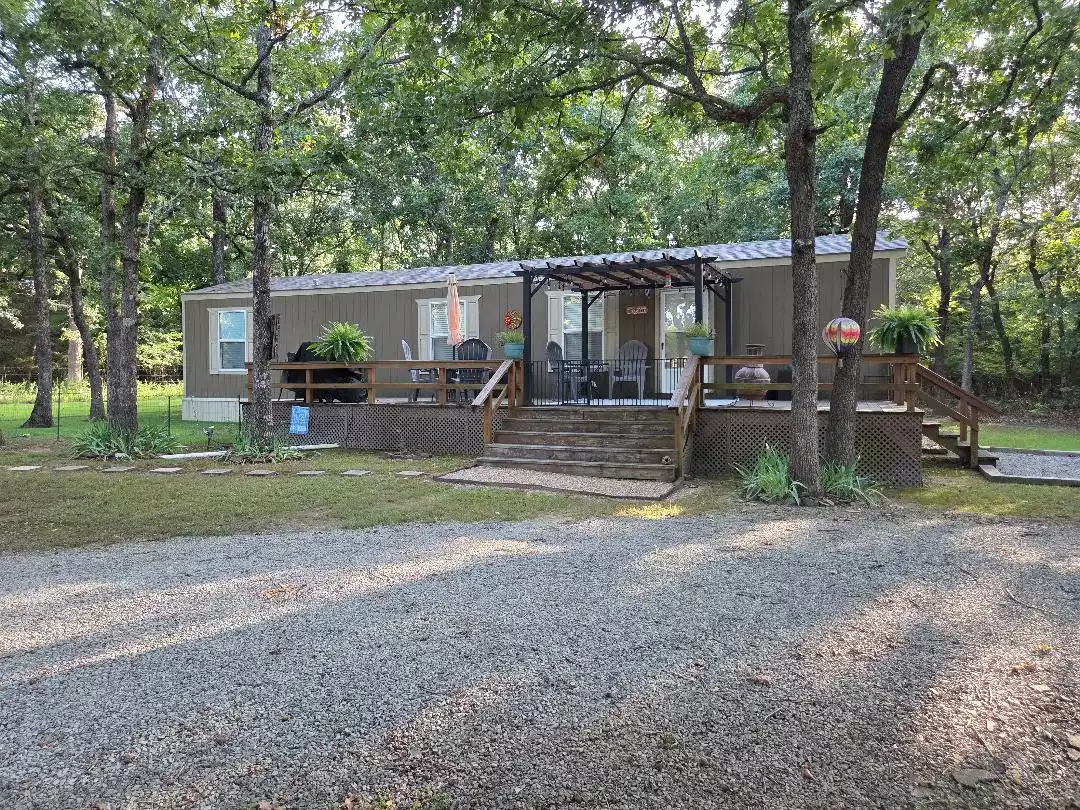 Image 1: Exterior residence with a gravel driveway and surr