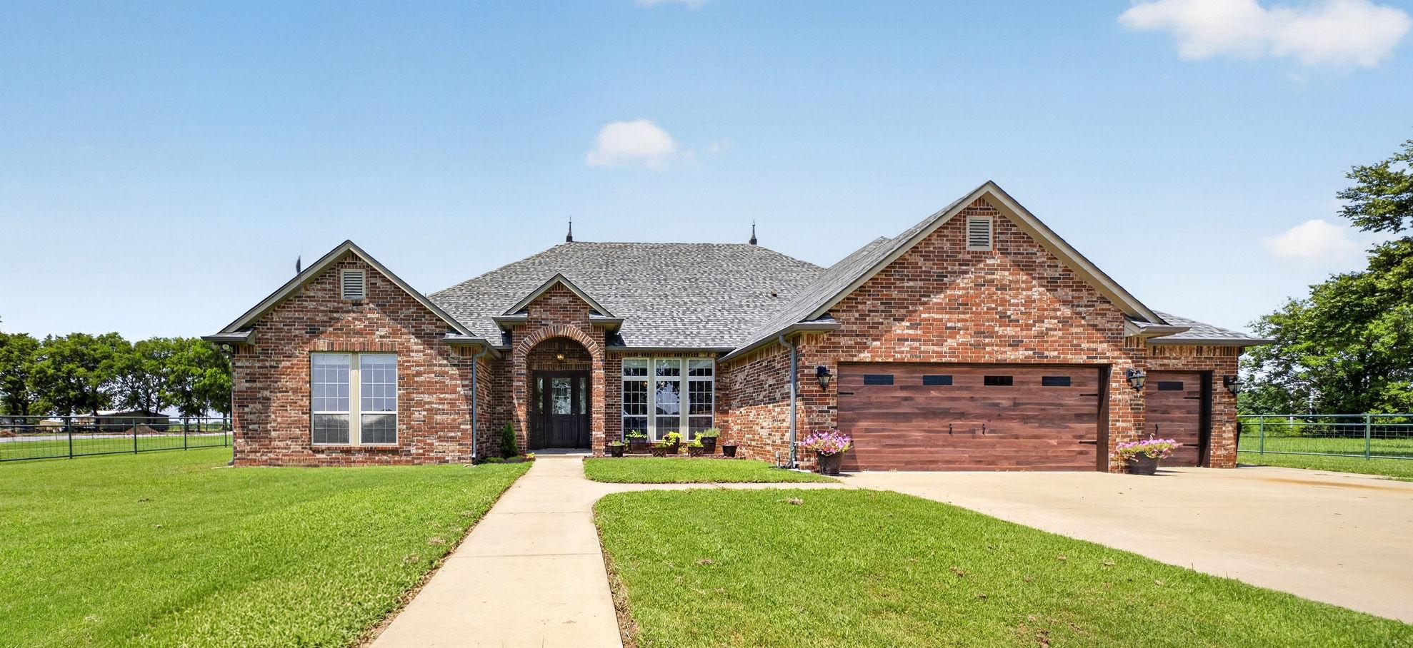 Image 2: Brick exterior featuring gabled rooflines and a ce