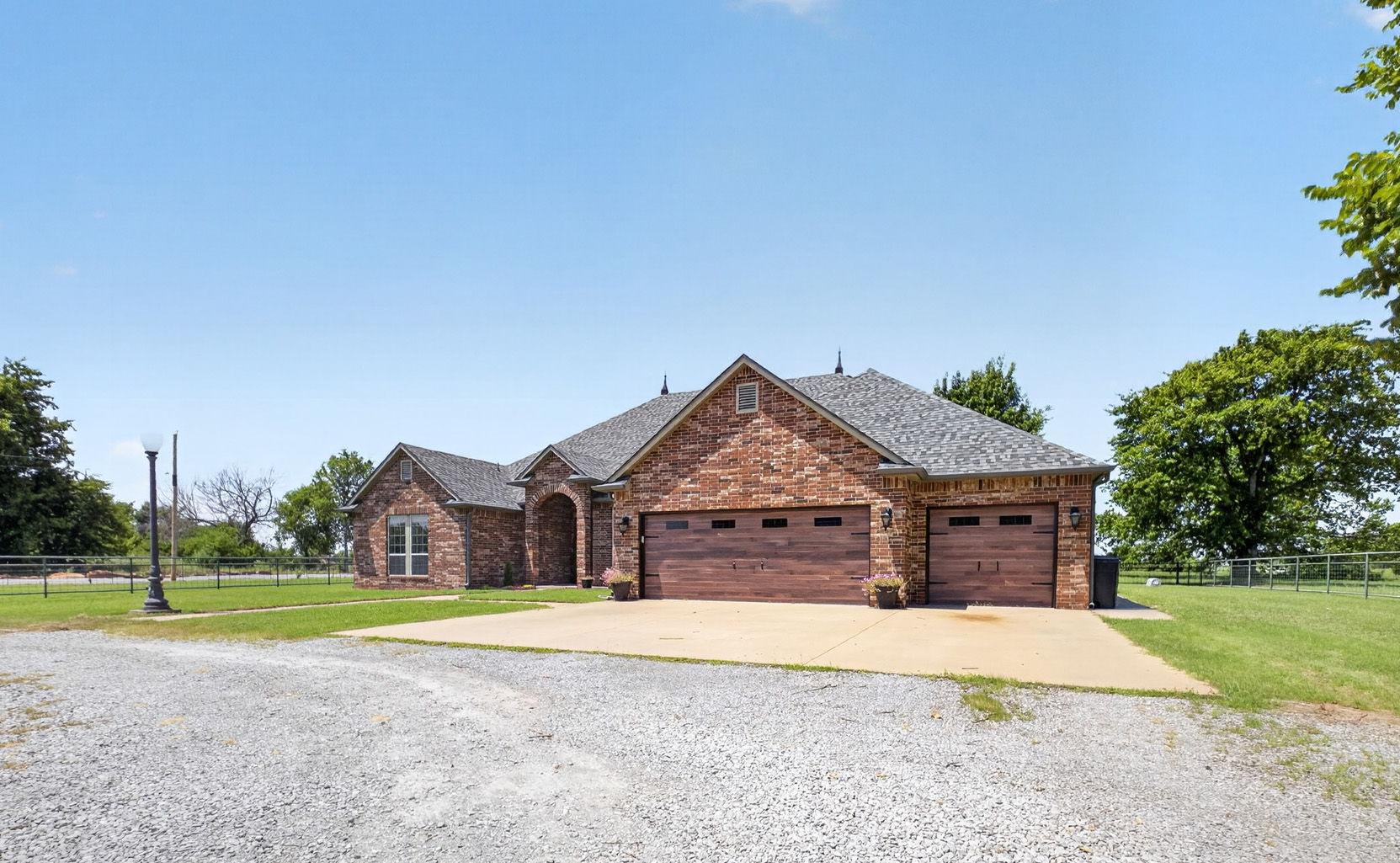 Image 4: Brick exterior with a multi-car garage featuring w