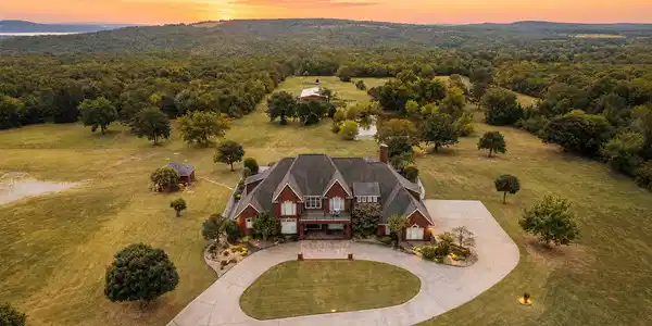 Image 4: Brick exterior residence with a circular driveway,