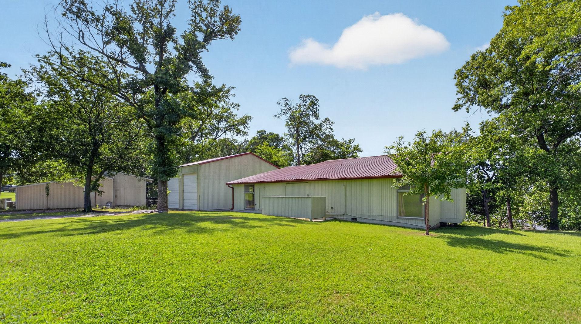 Image 3: Expansive green lawn with mature trees providing n