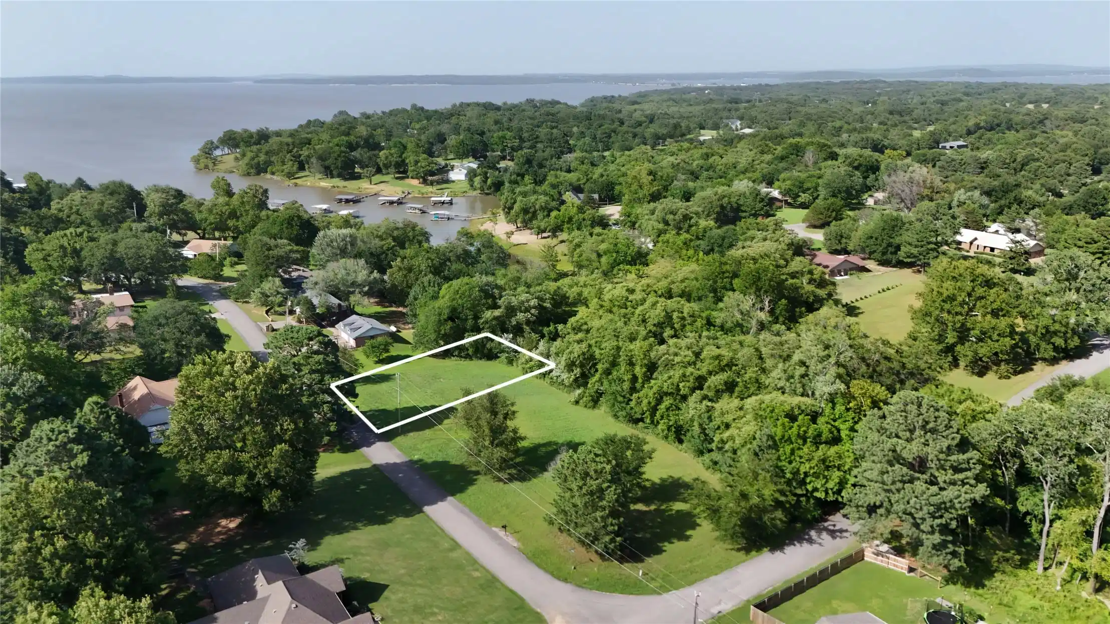 Image 1: Cleared residential lot featuring a verdant landsc