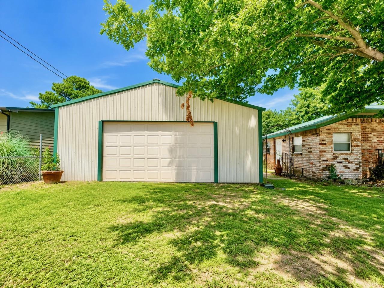 Image 3: Metal building with a white paneled garage door an