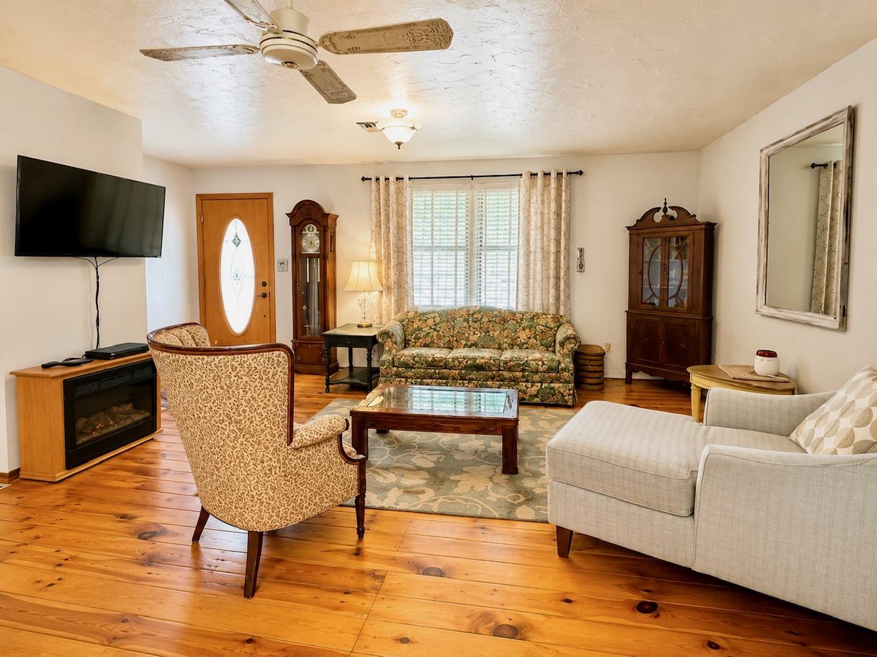 Image 4: Living area featuring wood-finish flooring, white
