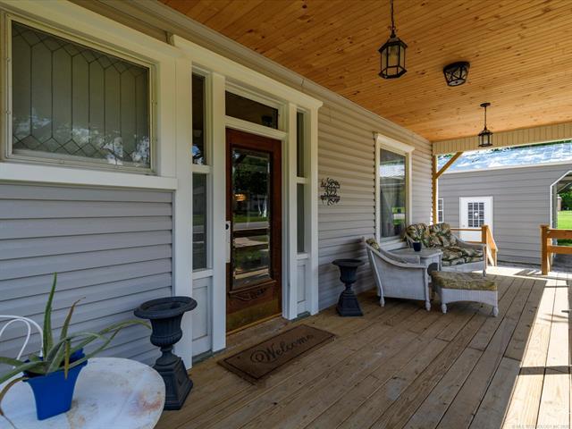 Image 2: Expansive covered porch featuring a natural wood-f