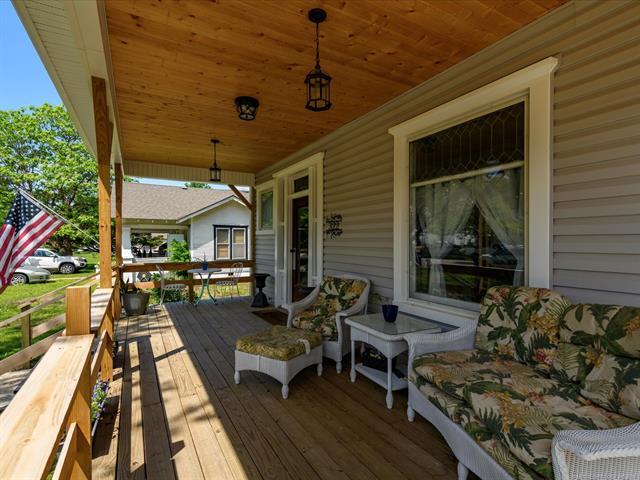 Image 3: Inviting covered porch featuring a natural wood pl