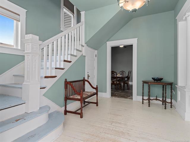 Image 4: Entryway featuring a white staircase with dark woo