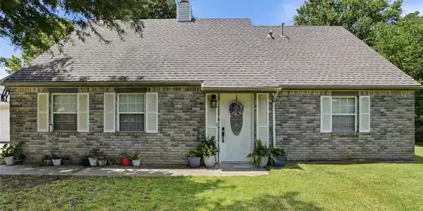 Image 3: Gray brick exterior featuring a white paneled fron