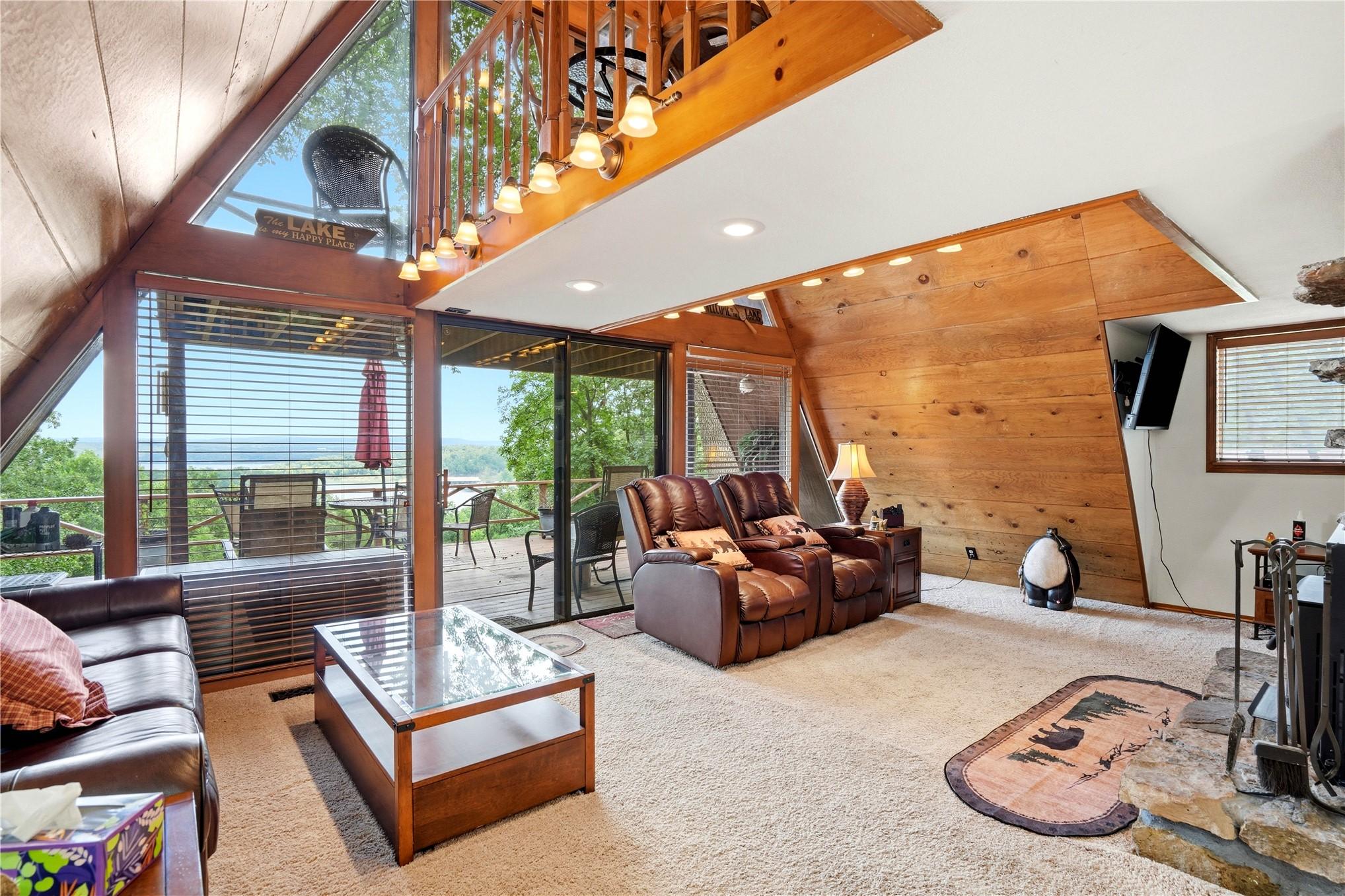 Image 4: Open-concept living space featuring a stone firepl