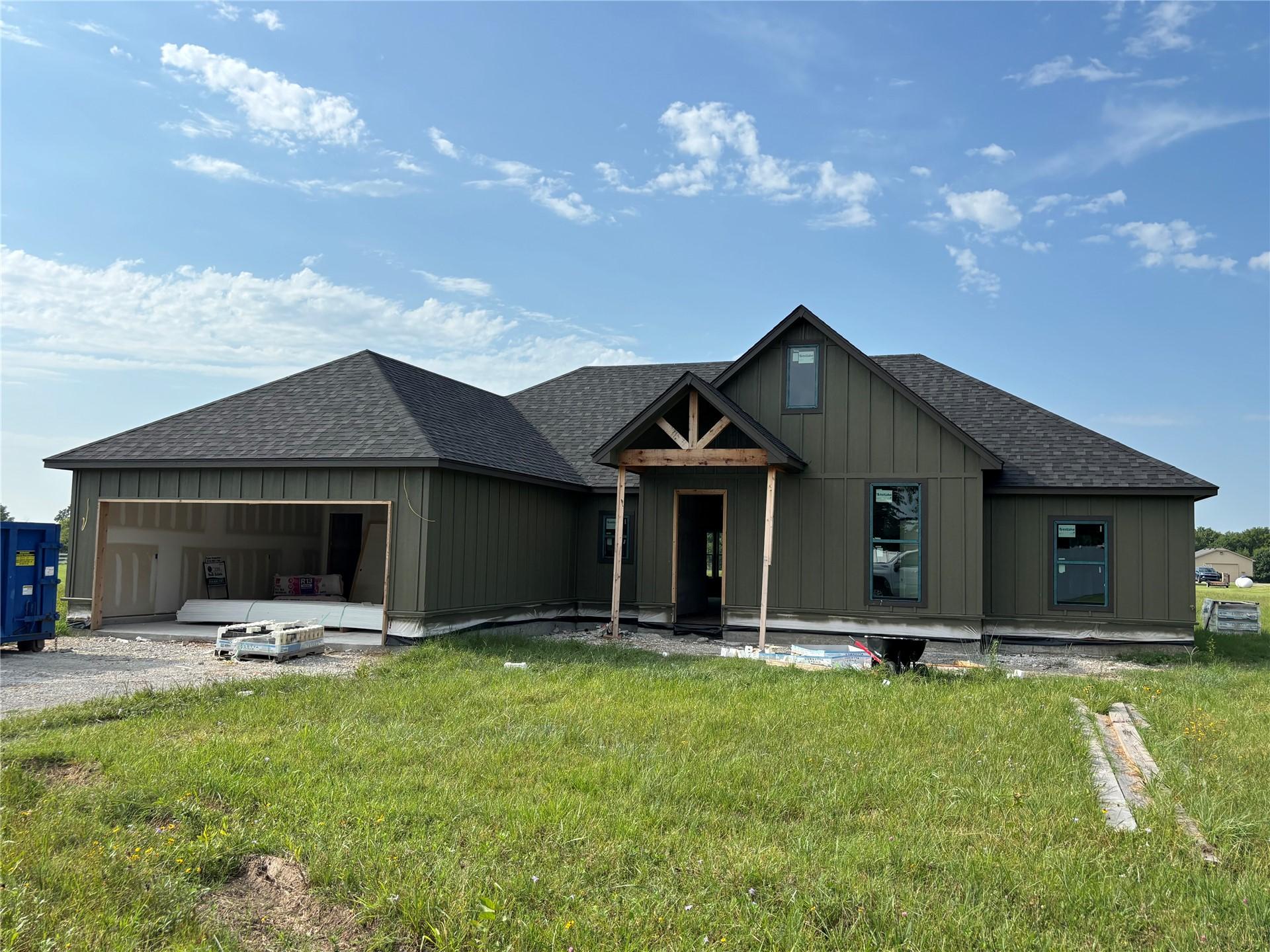Image 4: Single-story residence featuring dark green vertic