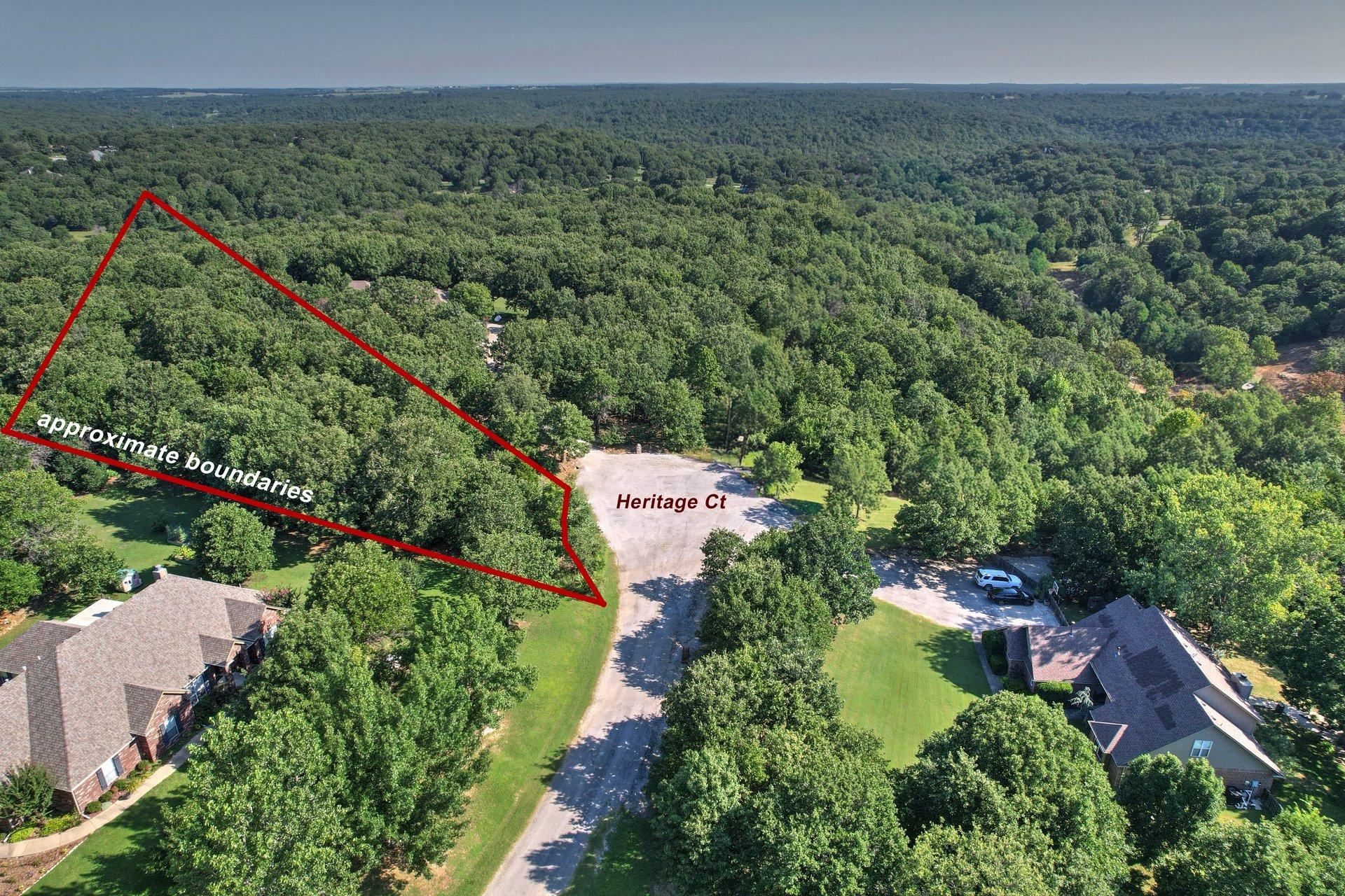Image 1: Wooded lot featuring mature trees along a paved cu