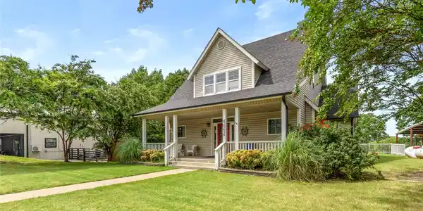 Image 2: Two-story residence featuring light-colored siding