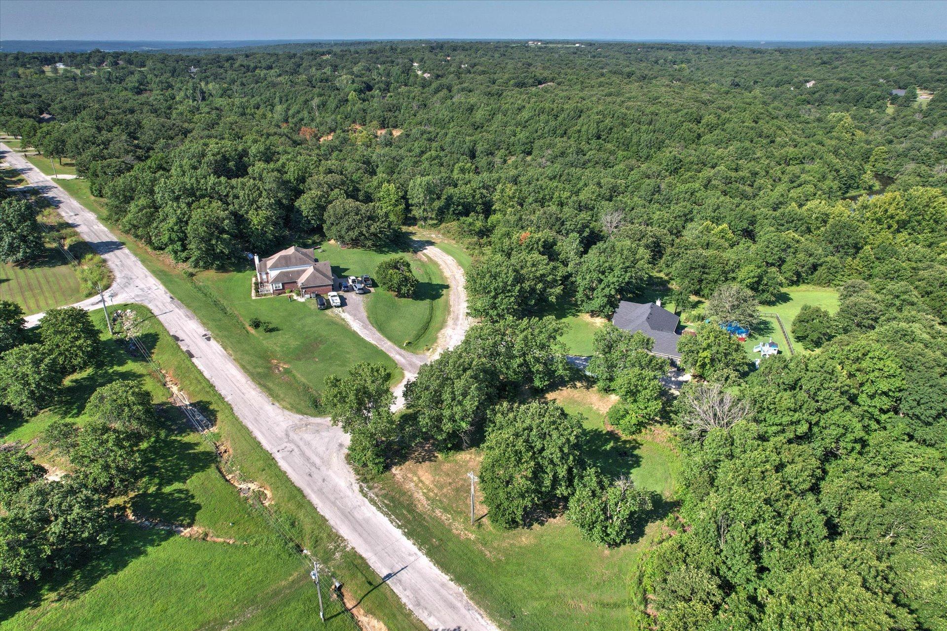 Image 1: Expansive wooded property featuring a primary resi