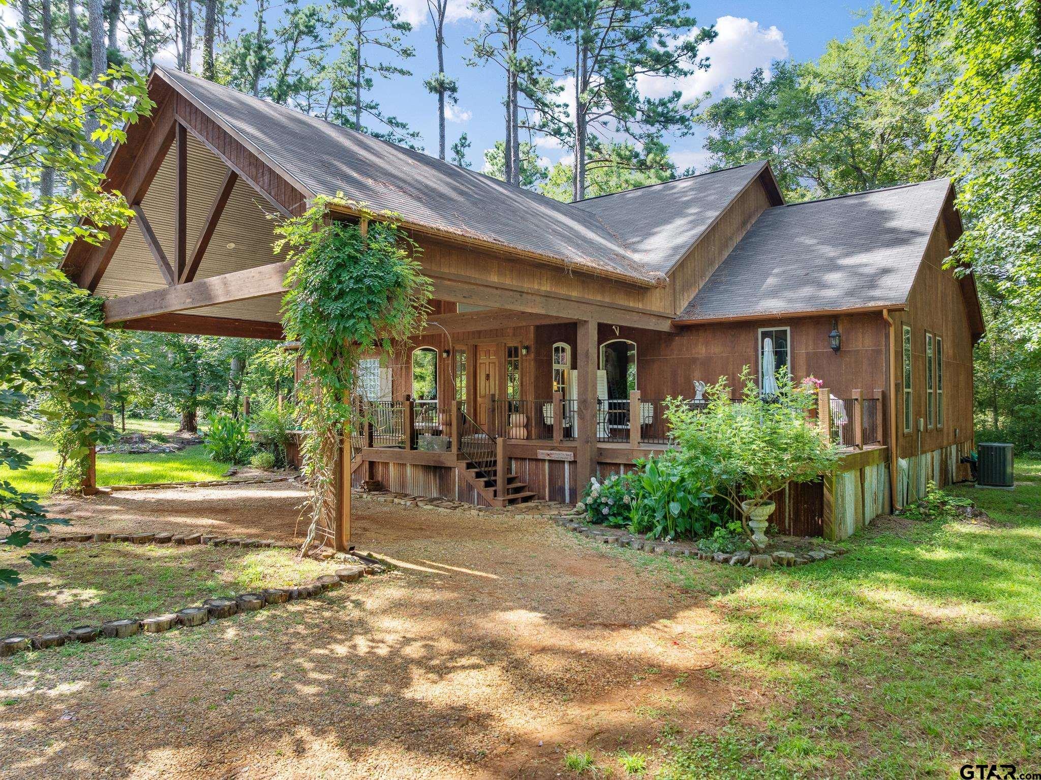Image 1: Tall & beautiful porte cochere with flowering vines attached to the front entrance., Porte cochere