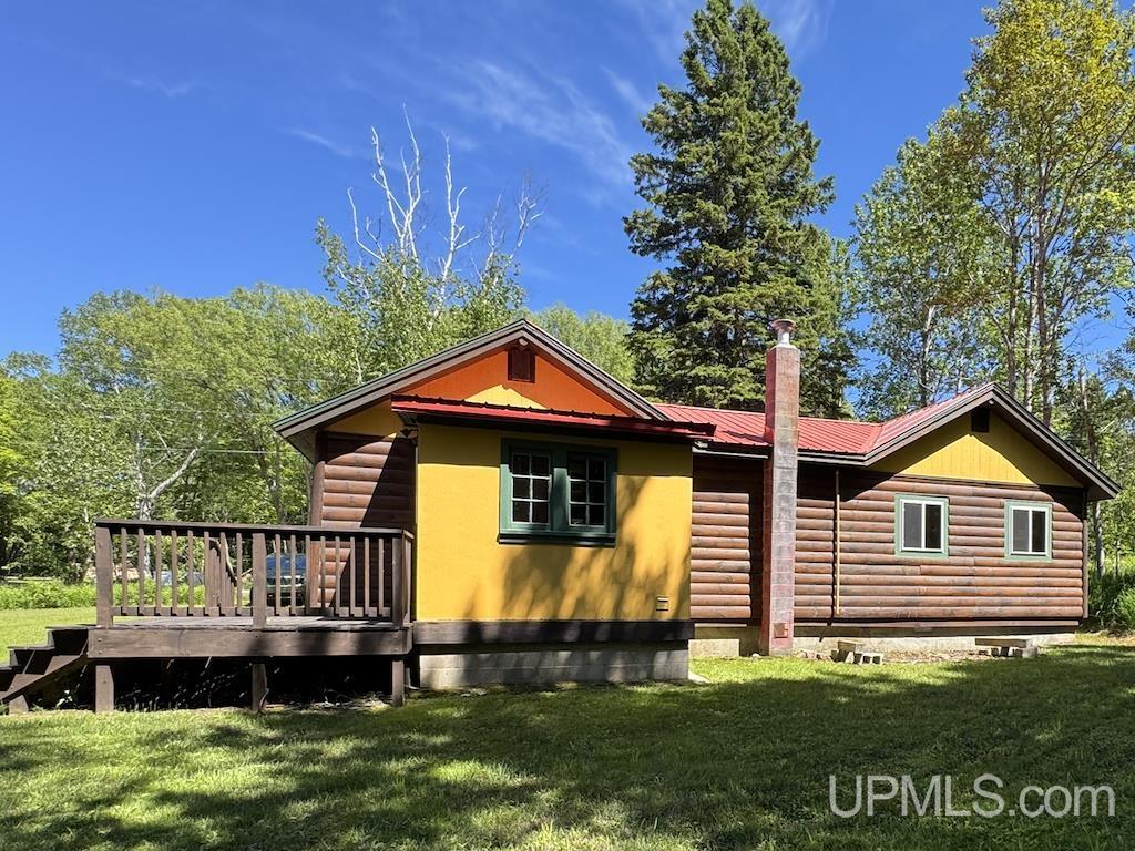 Image 1: Enter the rear of this lovely cabin through a covered porch., Rear