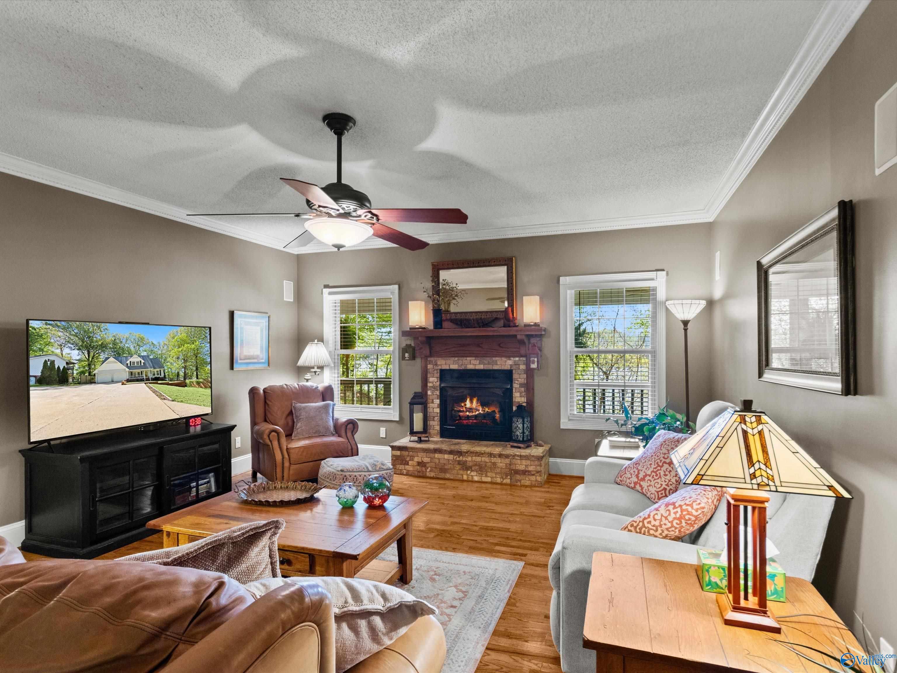 Image 4: Wood flooring, crown molding, ceiling fan, fireplace