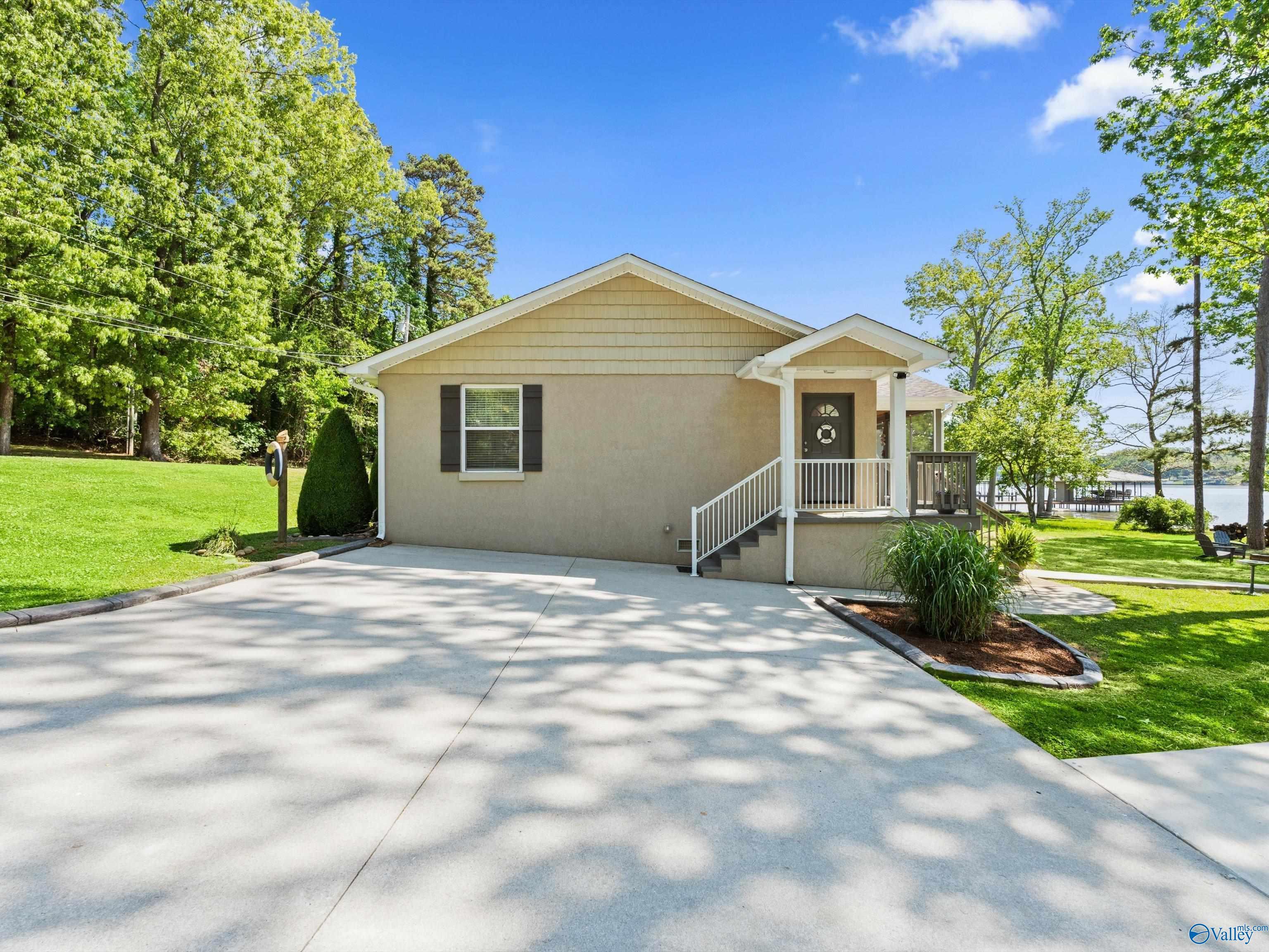 Image 3: Stucco, concrete driveway and parking area, covered home entry, beautifully landscaped, some mature trees for shade