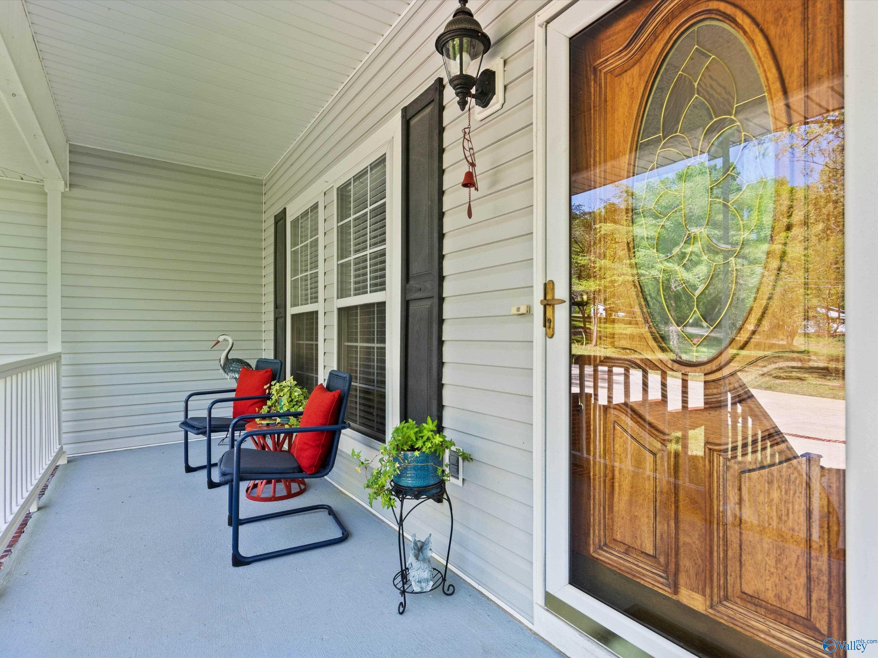 Image 3: Covered front porch with railing and home entry