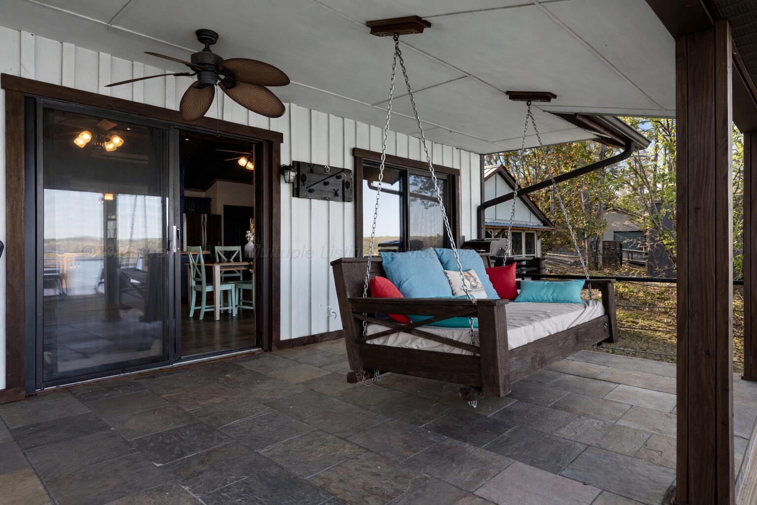 Image 3: Cozy patio with wooden swing and cushion