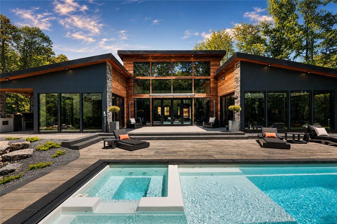 Image 1: An inviting backyard oasis offers a serene pool, s