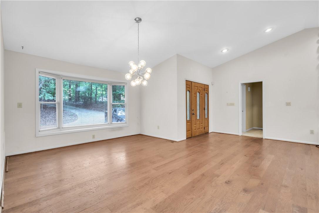 Image 3: Hardwood floors and a wide bay window define this