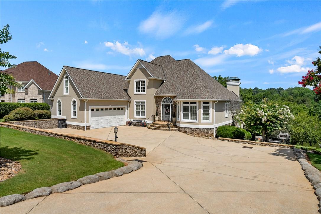 Image 1: A grand residence with a paved driveway, stone acc