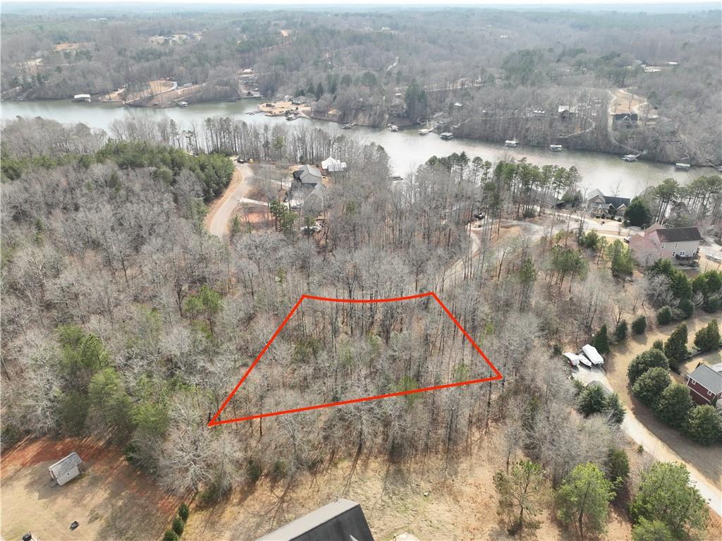 Image 2: This aerial view showcases a wooded lot offering t