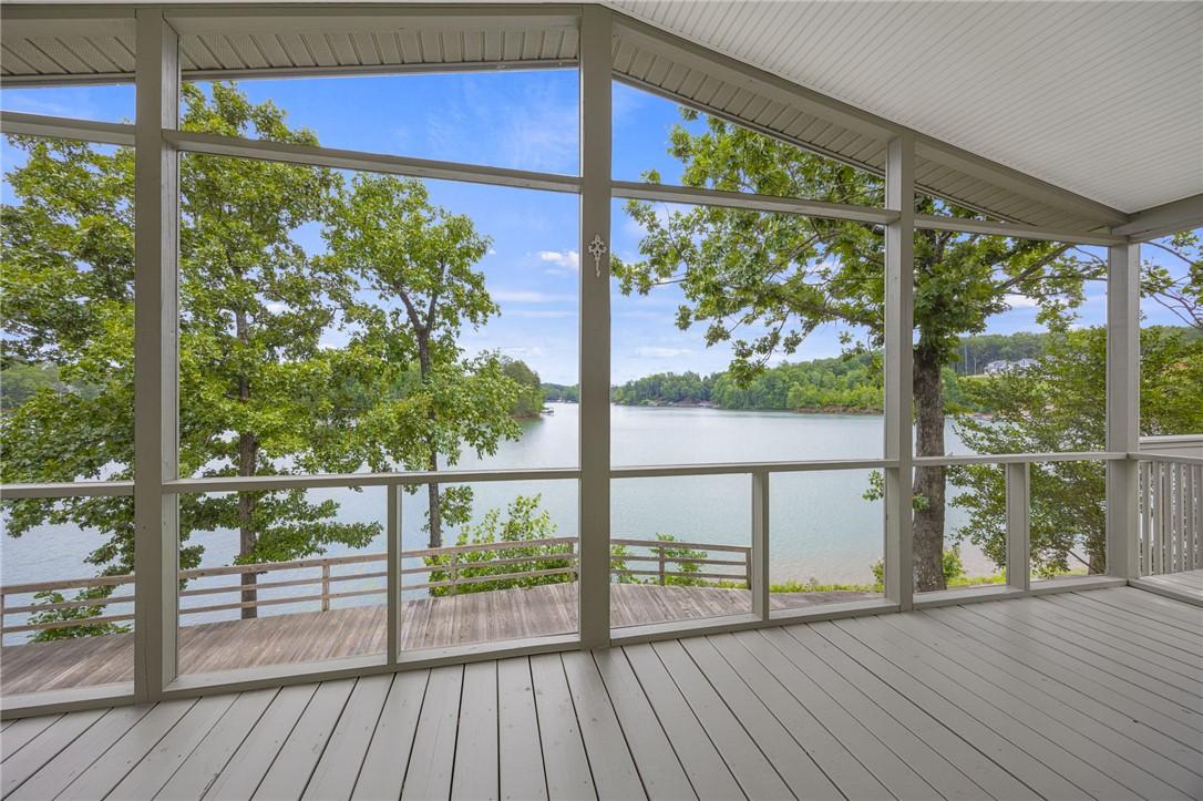 Image 3: A spacious screened porch overlooks a tranquil lak