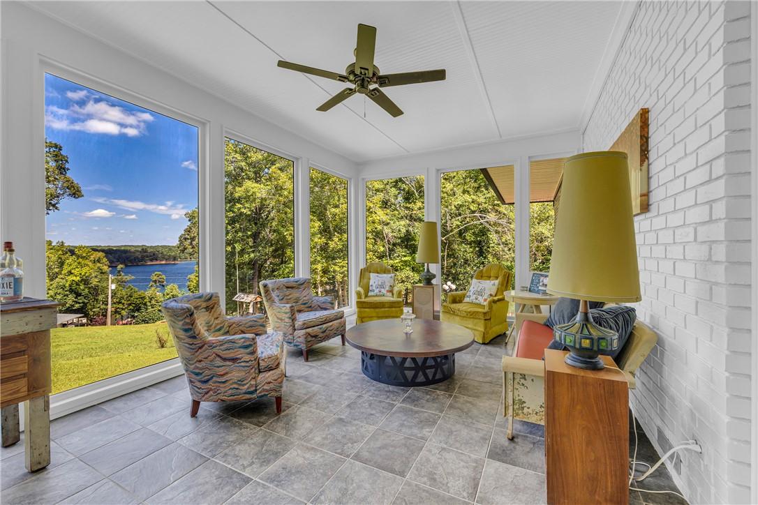 Image 3: A tranquil sunroom provides panoramic lake views,