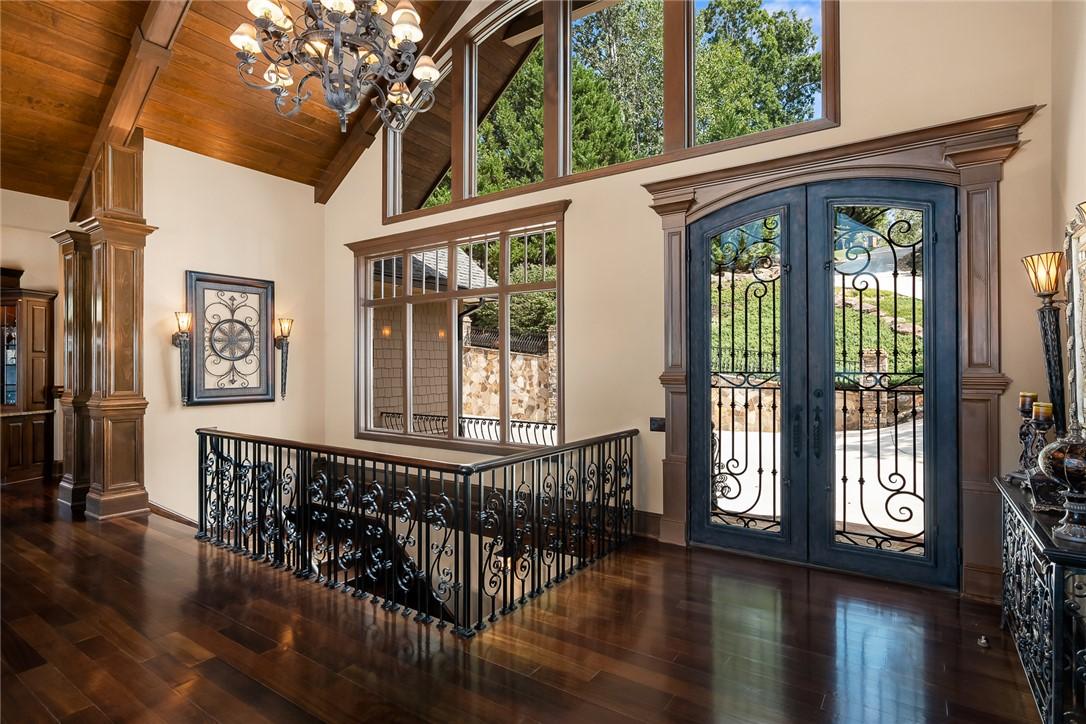 Image 4: Grand entryway with rich hardwood flooring, soarin