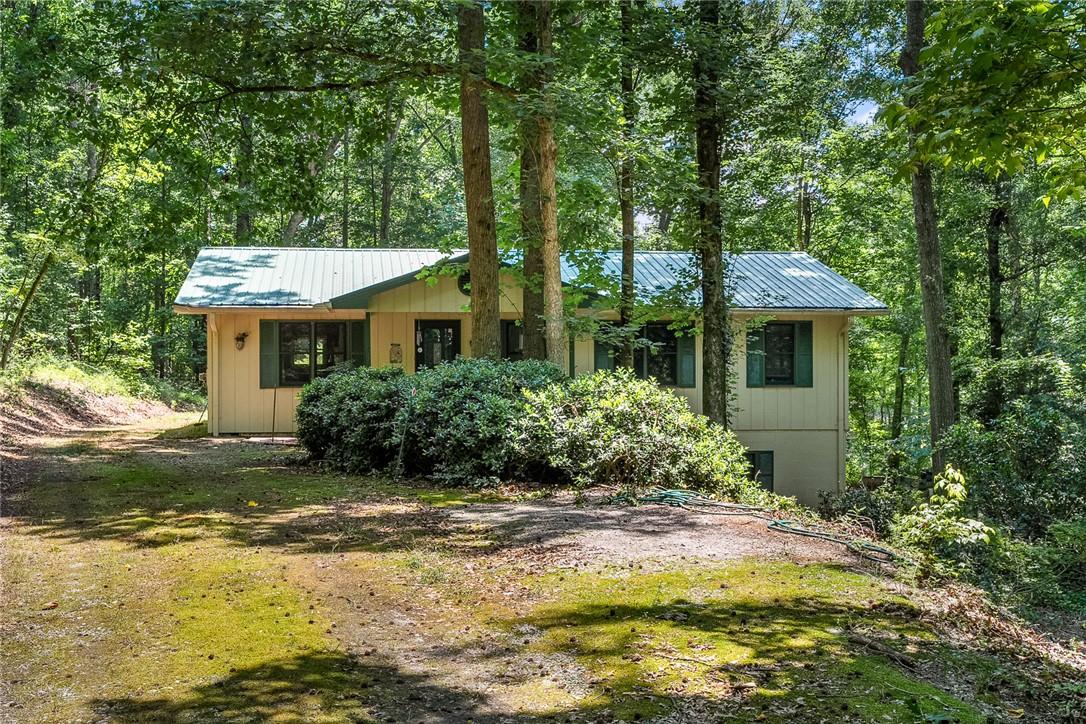 Image 1: Nestled in a verdant setting, this home offers tra