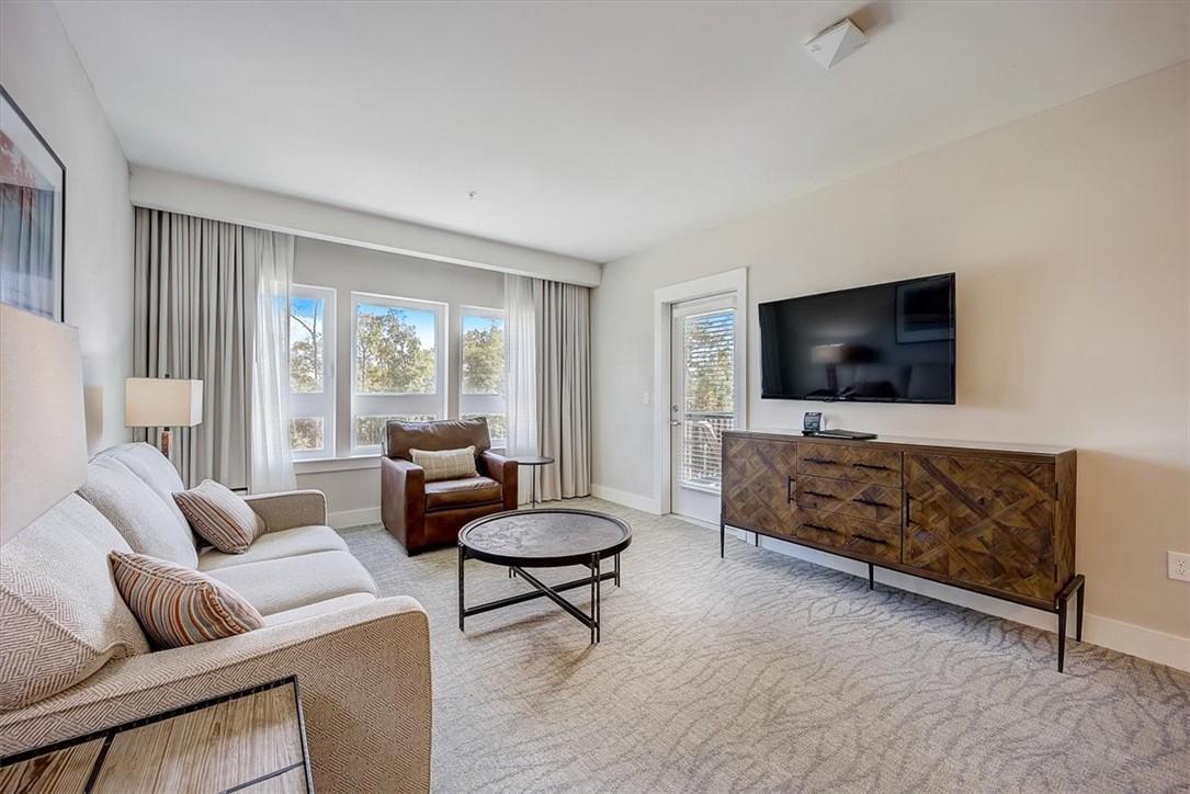 Image 4: A well-lit living area offers comfort with a priva