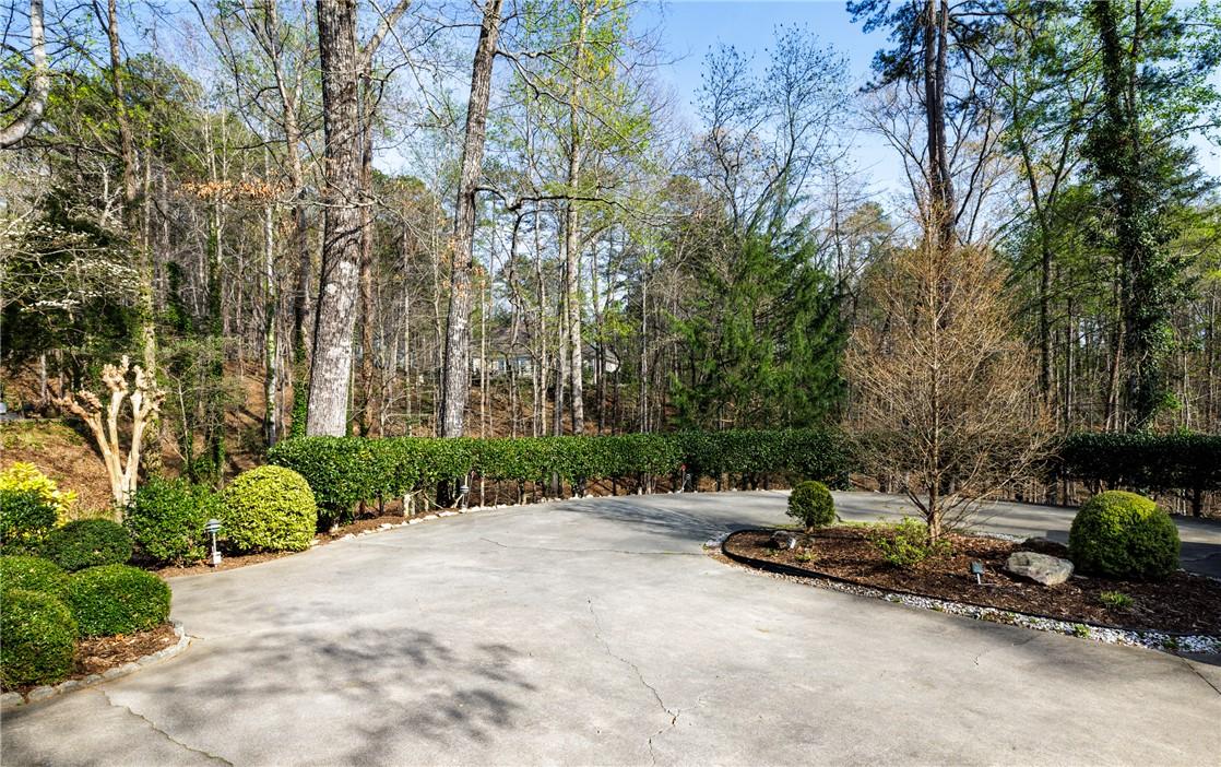 Image 4: A verdant retreat, this property offers a paved dr