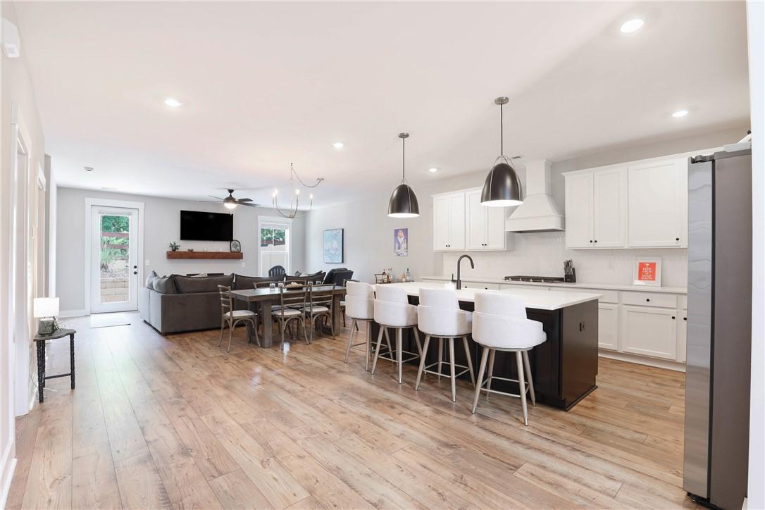 Image 3: An open-concept living area boasts a sleek kitchen