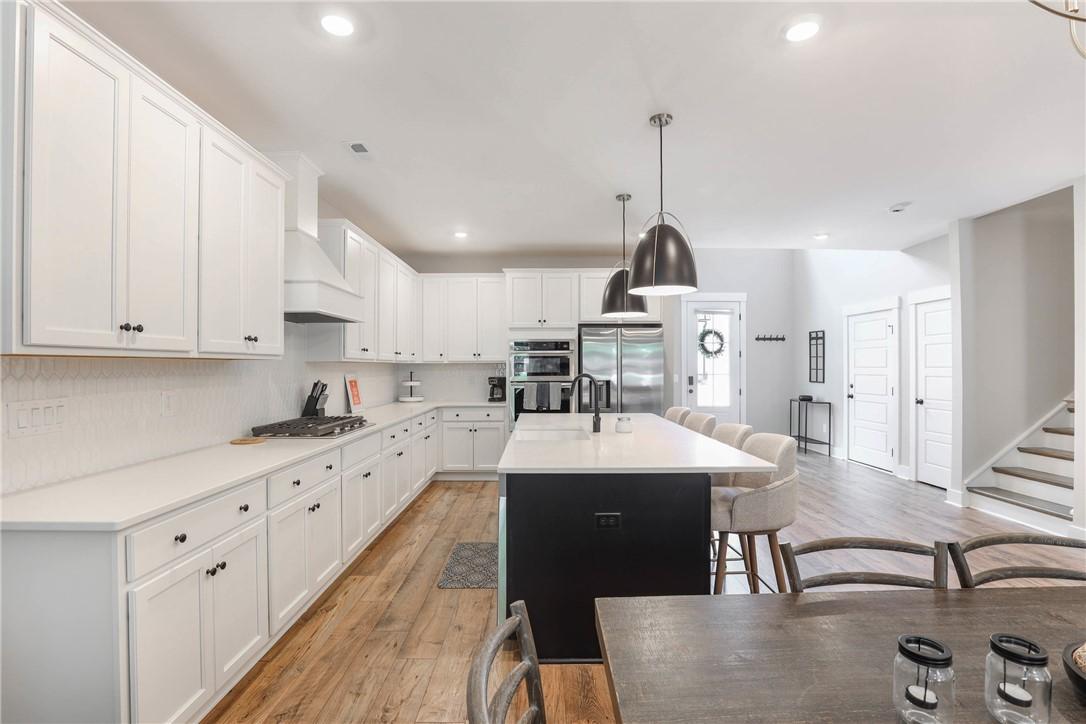 Image 4: A well-lit kitchen features an expansive island, w