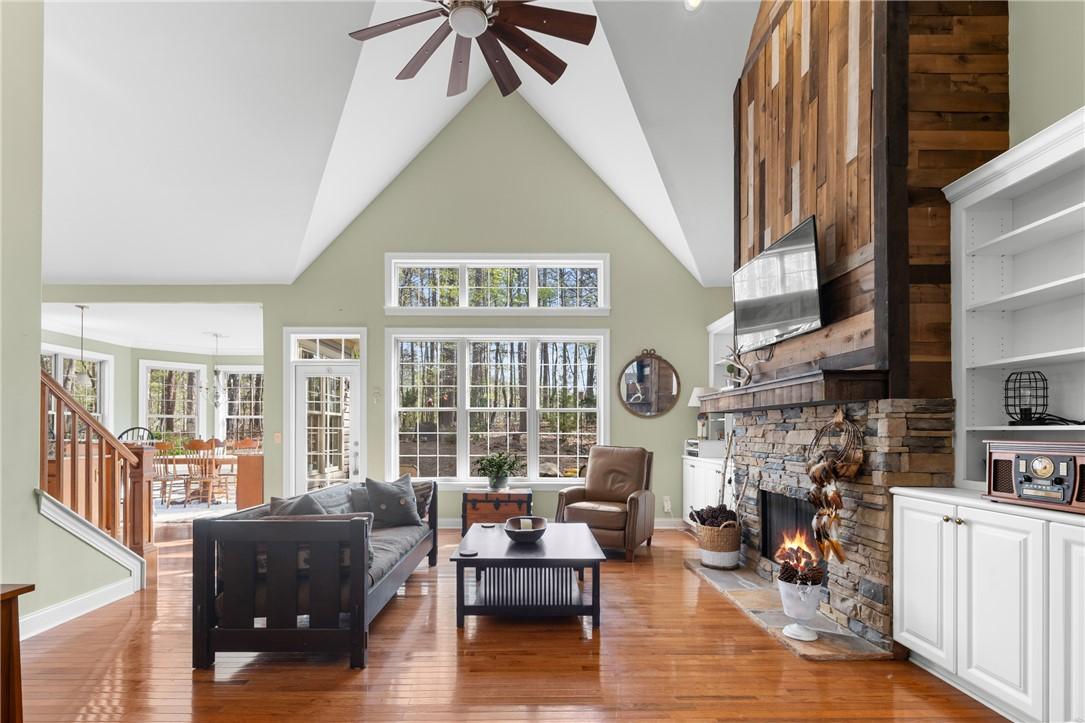 Image 2: Bright and airy living area featuring a stone fire