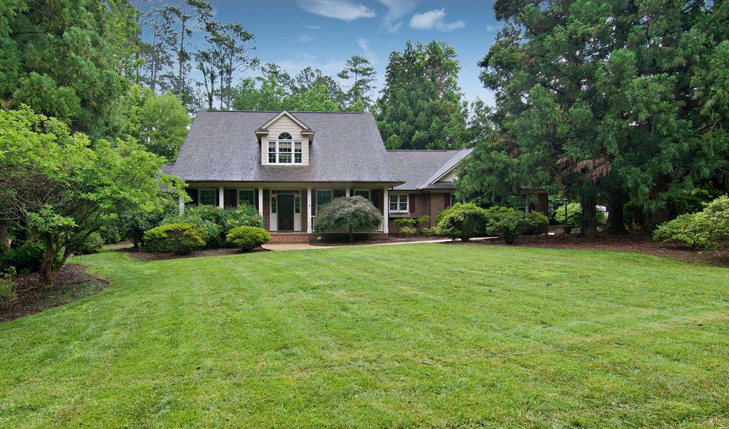 Image 1: A classic brick residence nestled amidst verdant l