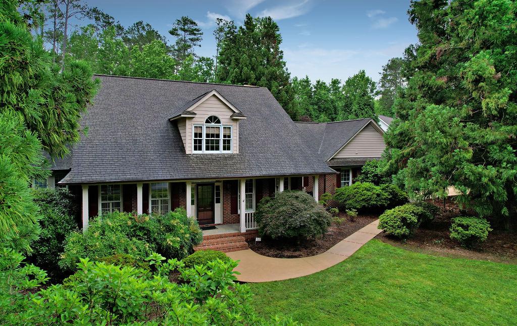 Image 2: Mature trees and lush landscaping frame this invit