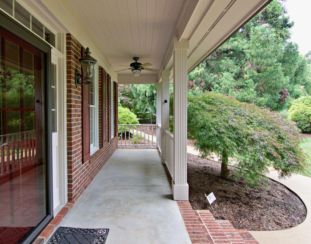 Image 3: A welcoming front porch features classic brick, st
