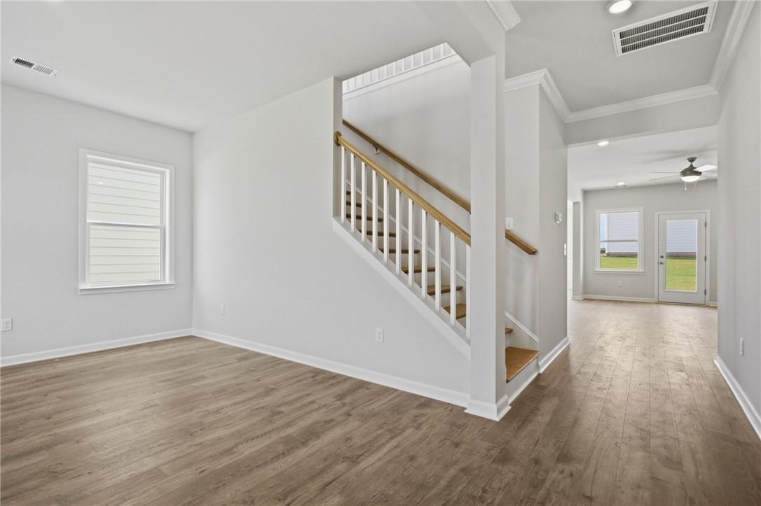 Image 4: A well-lit interior features warm wood flooring an